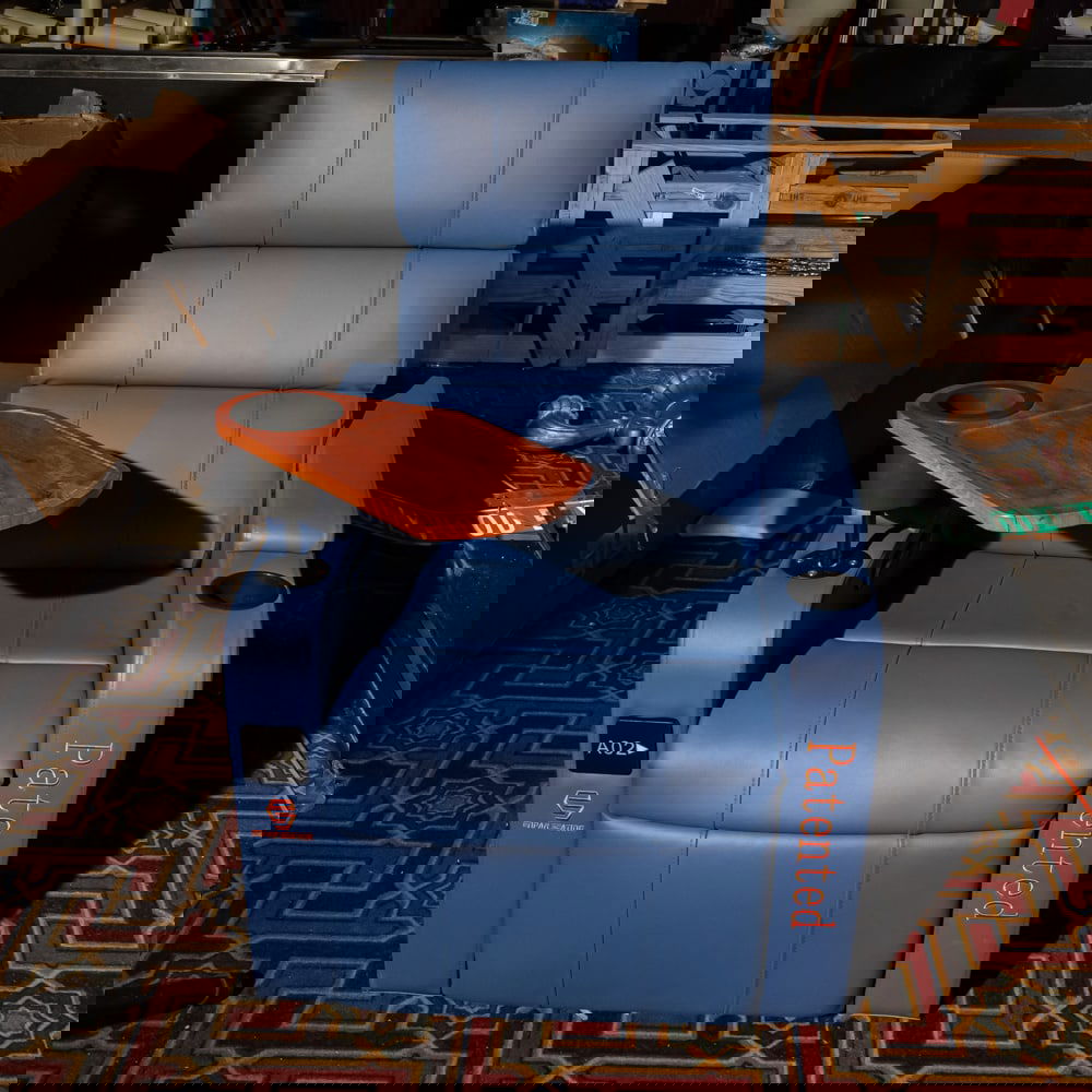 Blue Leather Cinema Recliner w/ Tray: This is a professional-grade, modern cinema recliner upholstered in a vibrant blue leather or high-quality faux leather, featuring a integrated swivel wooden snack tray and dual cup holders. The