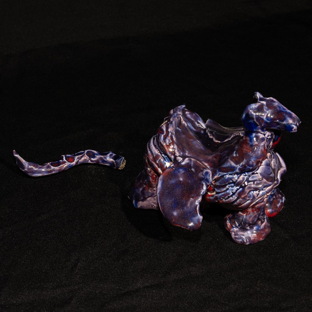 Signed Ronna DeMyers Studio Pottery Dragon: This unique studio pottery piece features a striking, organic form finished in a rich, multi-tonal purple and blue glaze with deep red undertones. Hand-sculpted by artist Ronna DeMyers, the figure dis