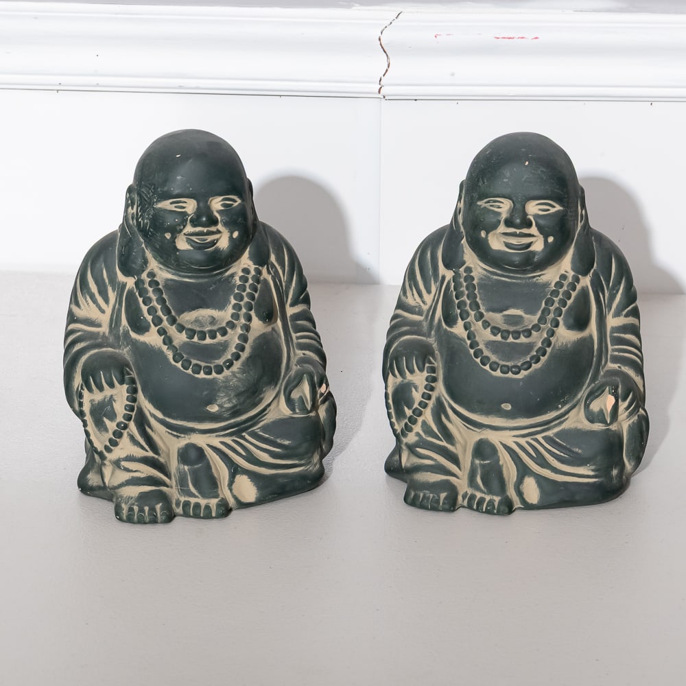 Pair of Green-Washed Ceramic Buddhas: These seated Hotei figures, often referred to as the "Laughing Buddha," feature a unique dark finish with a notable green-tinted wash or faux-patina that accentuates the depth of the casting. The heav