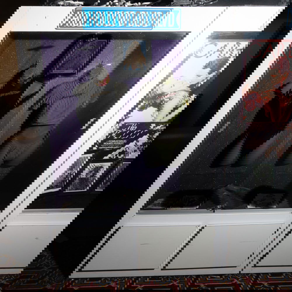 Tall Lighted Display Case: Lighted white Formica display case with 2 sliding glass front entry doors. Cabinet has 2 door storage below. In used condition. Measures 76" tall,50" wide, 20" deep. Please use photos to judge conditi