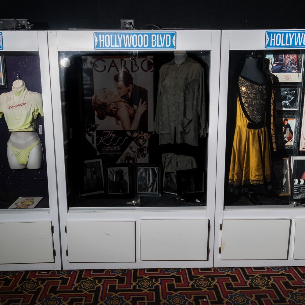 Tall Lighted Display Case: Lighted white Formica display case with 2 sliding glass front entry doors. Cabinet has 2 door storage below. In used condition. Measures 76" tall,50" wide, 20" deep. Please use photos to judge conditi