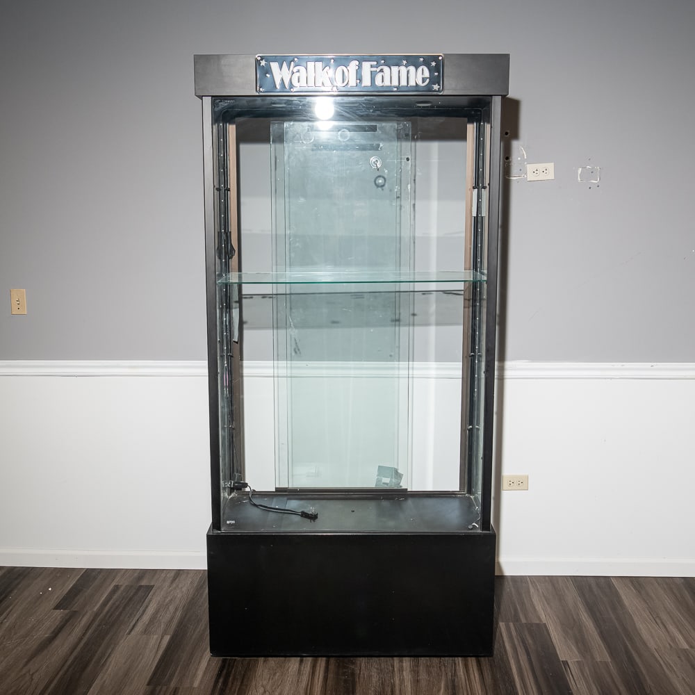 Professional Lighted Glass Display Case: This is a high-quality retail or gallery-grade display cabinet, featuring a robust black laminate frame and expansive tempered glass panels for 360-degree visibility. The unit is equipped with a mirro