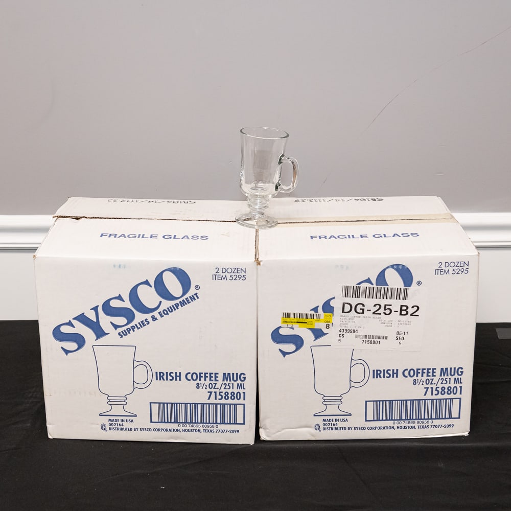 96 Sysco 8.5oz Irish Coffee Mugs: This lot features four cases (totaling 96 pieces) of classic Irish Coffee mugs distributed by Sysco Supplies & Equipment. These are professional-grade, clear glass vessels featuring a traditional pede
