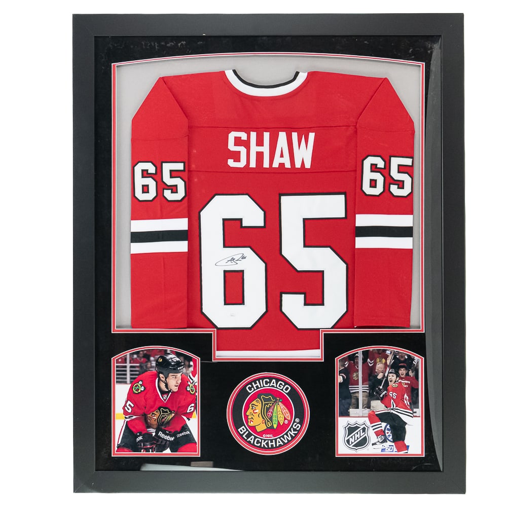 Framed A. Shaw AUTOGRAPHED Blackhawks Jersey JSA: Framed Andrew Shaw AUTOGRAPHED Chicago Blackhawks #65 Jersey with JSA COA. Perfectly presented with custom framing & matting and strong bold black signature; approximately 43.5"t x 35.5"l. Bottom corn