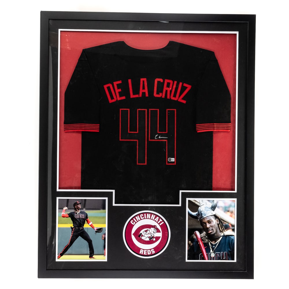 Elly De LA Cruz Framed AUTOGRAPHED REDS Jersey COA: Framed Elly De LA Cruz AUTOGRAPHED Cincinnati Reds Jersey with Beckett authentication. Attractive jersey is perfectly accented with bold SILVER felt tipped signature; approximately 42.5"t x 34"l. Prof