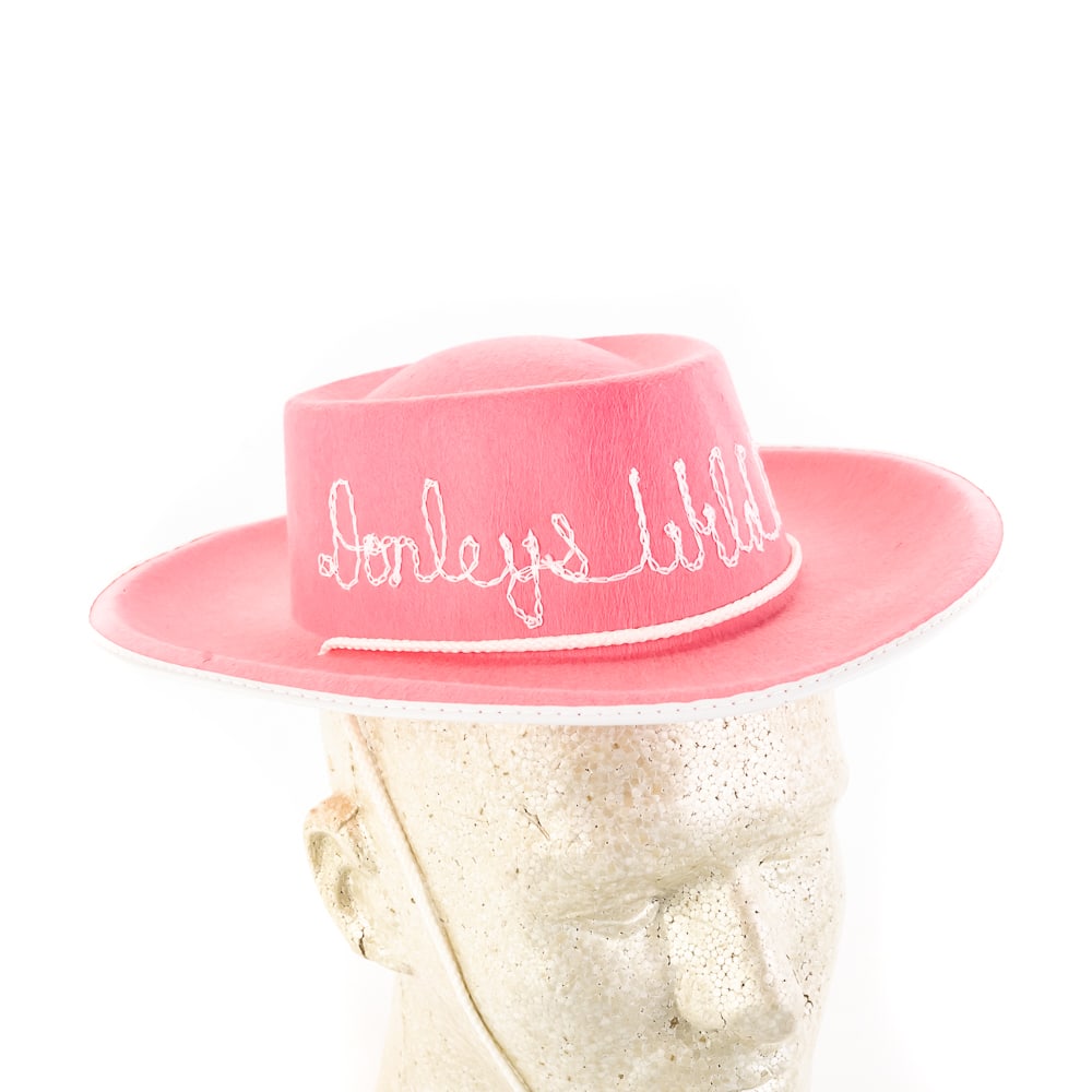 Kids Pink Felt Cowboy Hat from Donley's WWT: Kids Pink Felt Cowboy Hat from Donley's Wild West Town's Gift Shop, new old stock, features the phrase "Donley's Wild West" hand-embroidered across front of crown, star shaped sheriff's badge and