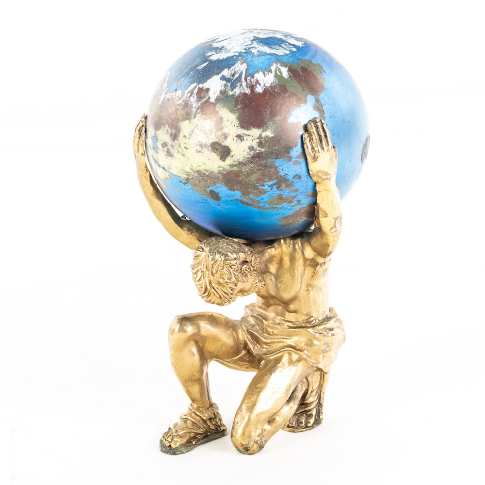 Lundberg Studio Glass Paperweight: Lundberg Studio glass paperweight with a and that depicts Atlas holding the planet. Measures approximately 3 1/2" in diameter by 3 1/4" in height. It is signed on the bottom. Condition is good.