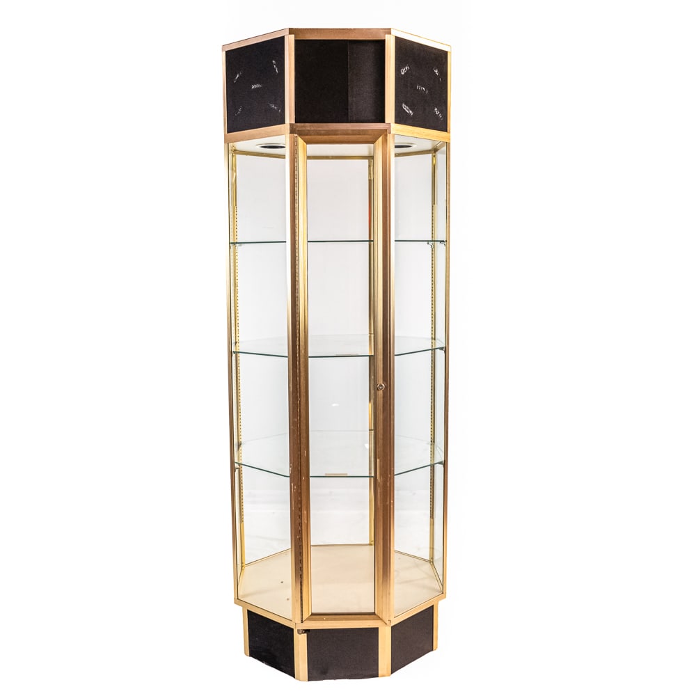 Octagon Glass Floor Showcase: Commercial style octagon shaped glass showcase with gold anodized aluminum frame. Top has 2 recessed lights. electric cord needs replacing. 11" single door entry has lock but no key. Comes with 3