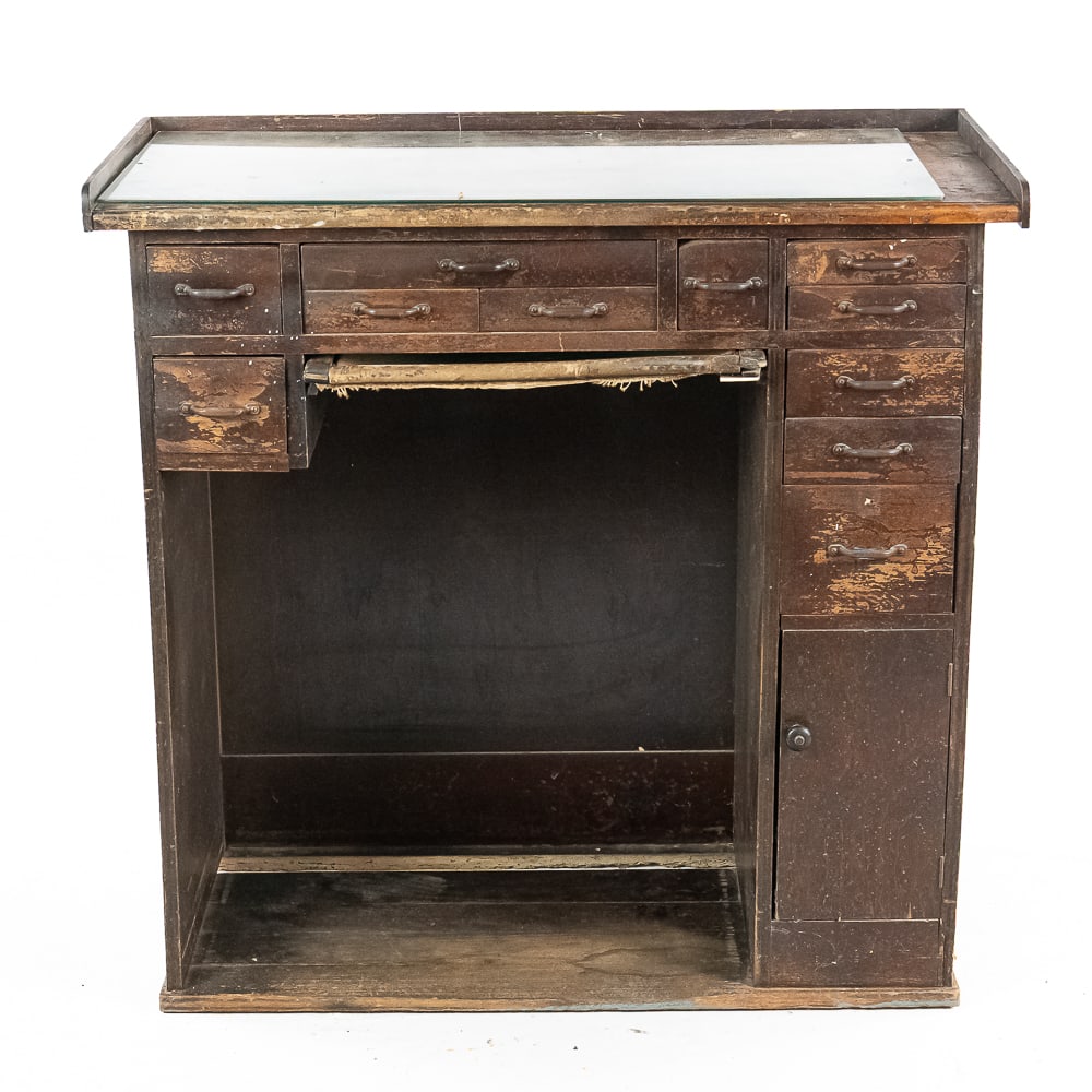 Jeweler's Work Bench: Classic tall jeweler's work bench in well used condition. Multi drawers for storage with iron pulls. Has the seldom seen pull out canvas filing catch for gold and silver. Currently has added glass
