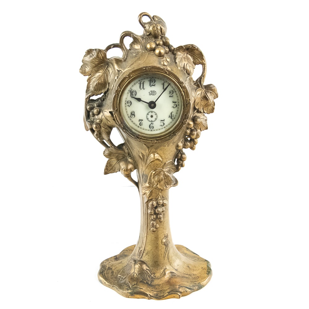 Art Nouveau Spelter Grapevine Clock: This is a quintessential Art Nouveau desk clock, likely dating from the early 20th century. The piece features a graceful, organic spelter case cast with a flowing grapevine motif, complete with detai