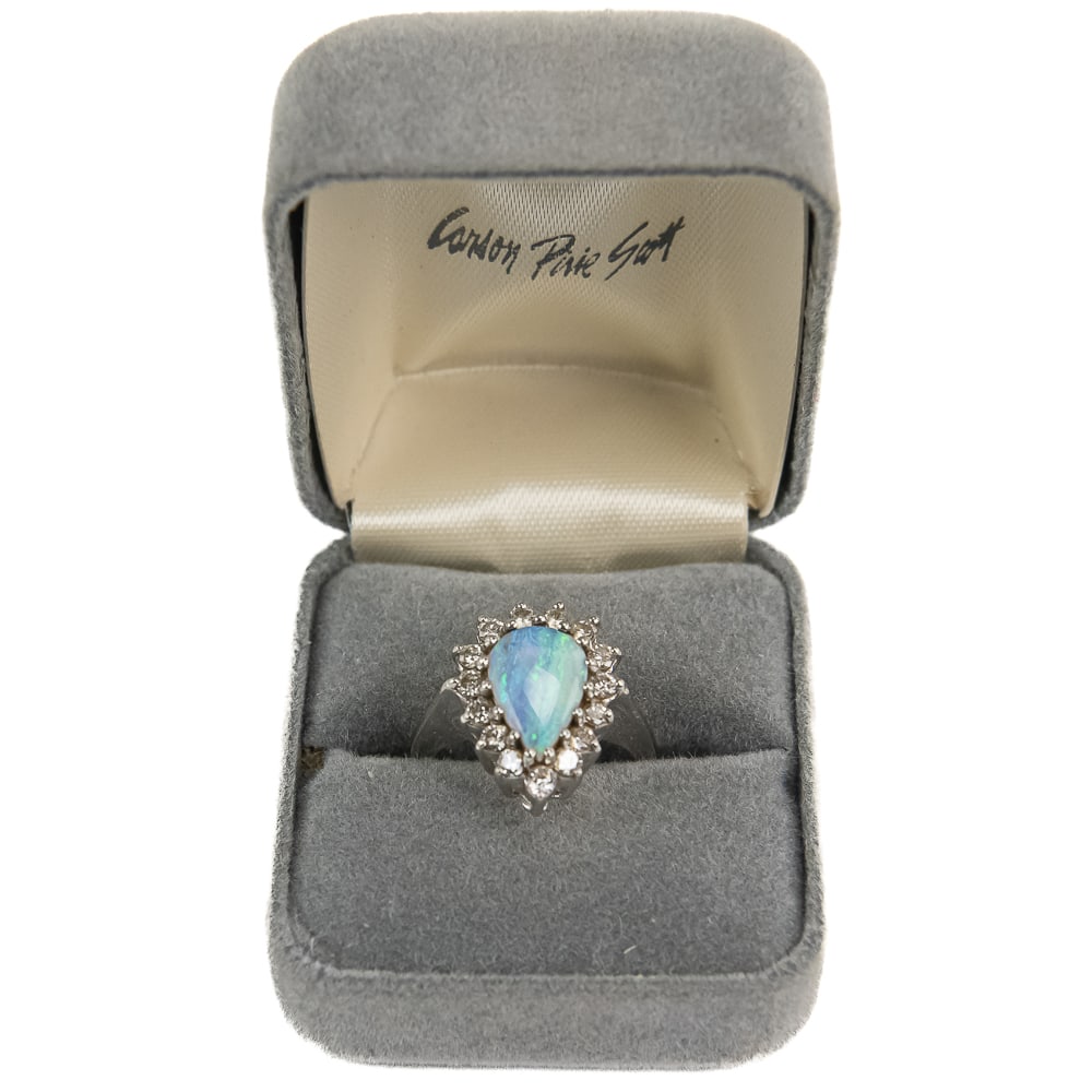 Ladies 14k White Gold Opal & Diamond Cocktail Ring: Ladies 14k White Gold Pear shaped 1.5 carat +/- Opal cocktail ring perfectly accented with a heavenly halo of (15) brilliant round cut diamonds. Centralized pear shaped cabochon opal displays a rainbo