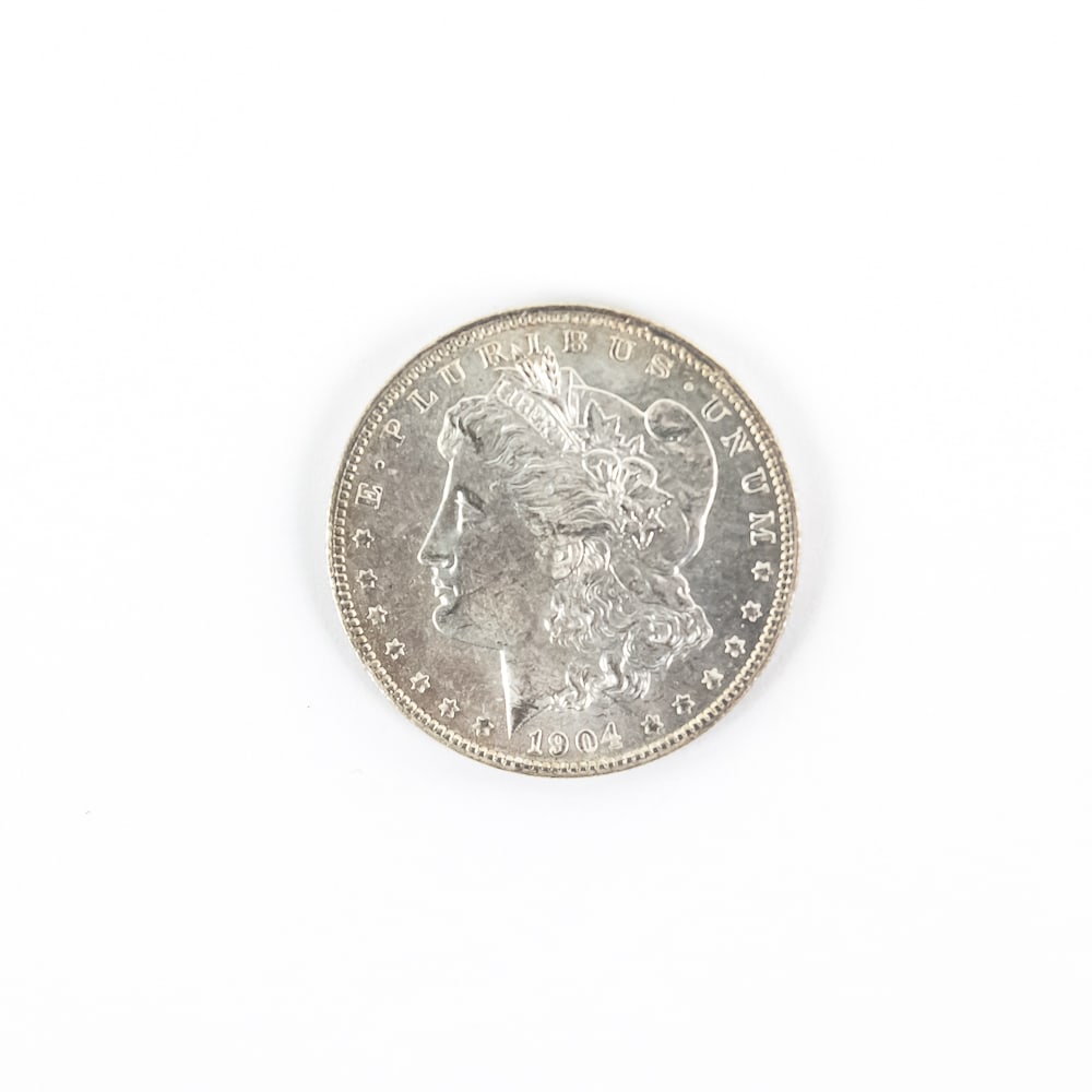 Uncirculated 1904-O Morgan Silver Dollar $1: Lustrous uncirculated 1904-O Morgan Silver Dollar (MS-AU). Silver is an excellent way to combat rising inflation. Perfect addition to your collection, please use photos to judge condition and bid acco