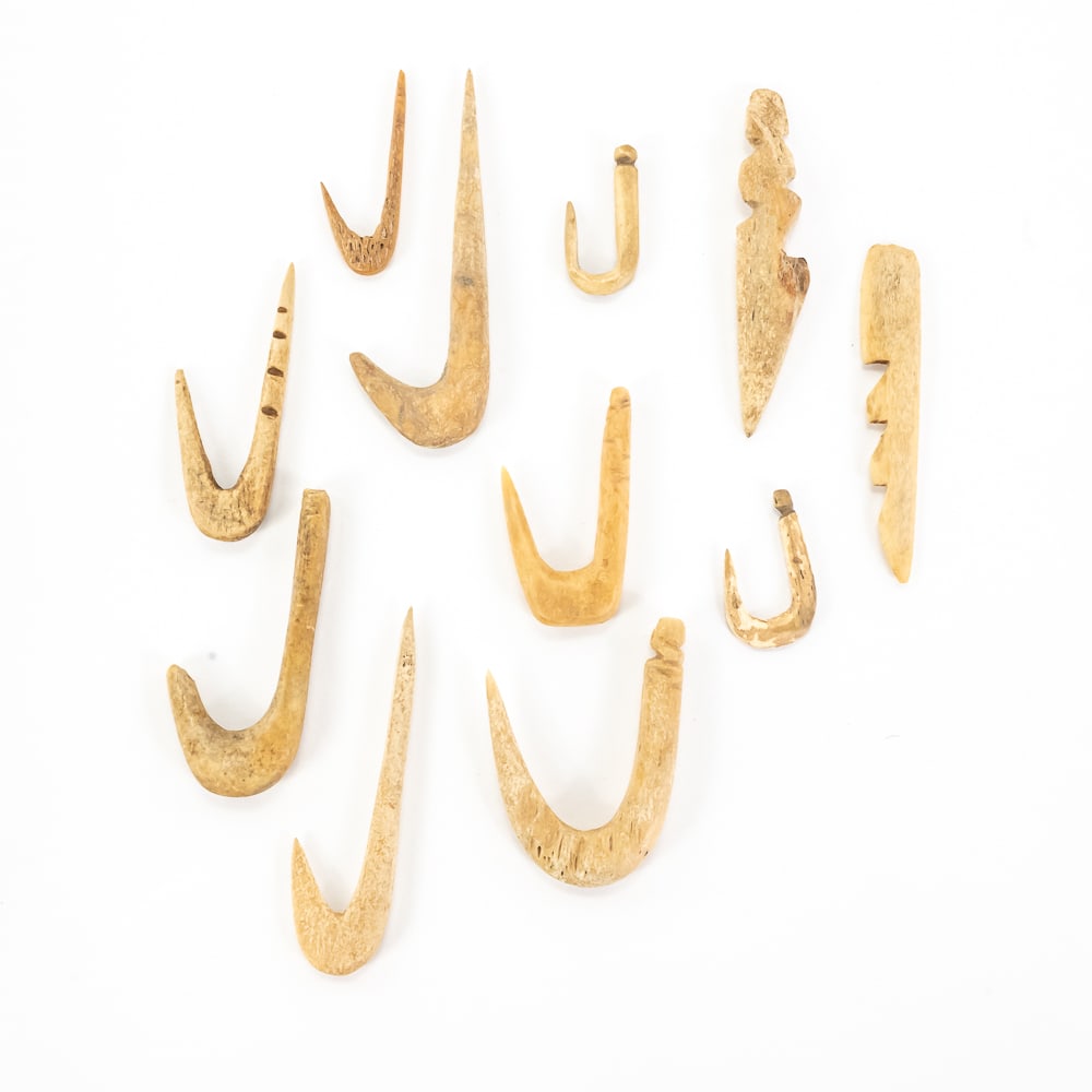 11pc Primitive Bone Fish Hook Collection: This collection features eleven hand-carved bone implements, primarily fashioned as "one-piece" fish hooks and specialized harpoon-style points. These pieces showcase the utilitarian artistry of