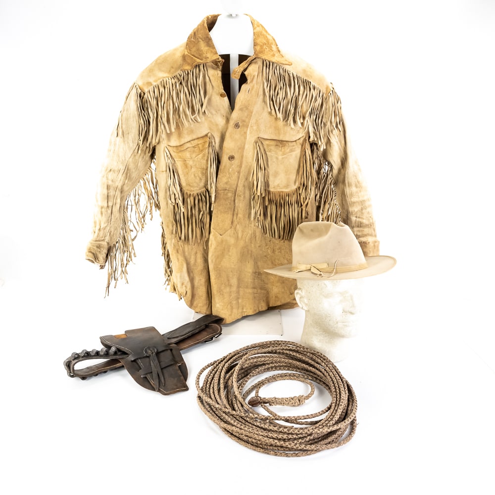 Vintage Western Stetson Hat, Gear & Jacket: This collection is a true frontiersman’s time capsule, featuring a vintage buckskin leather jacket with heavy fringe detailing, a braided rawhide lariat with a leather-wrapped honda, and a