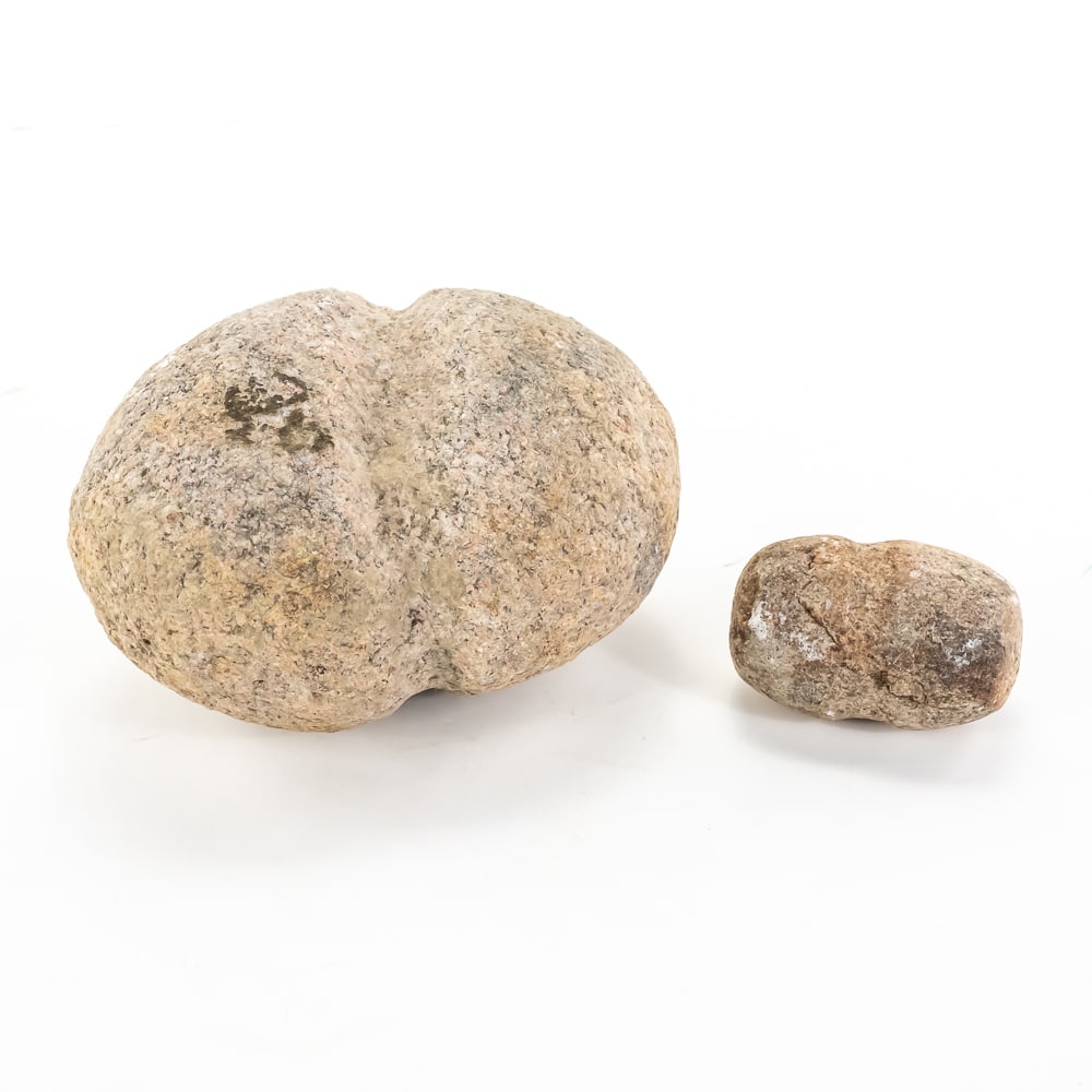 Two Native American Grooved Mauls (2): This pair of prehistoric-style stone tools, likely granite or quartzite, showcases the classic "full-groove" design used by indigenous peoples for heavy-duty tasks like processing bison or driving sta
