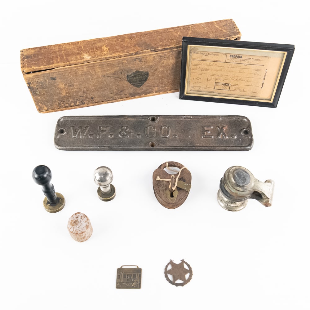 Lot of 10: Assorted Early Wells Fargo & Co Items: 1) Hand operated, spring type envelope stamp. 3" x 3"2) Two wax seal hand stamps 4" x 2 1/4"3) One vintage Bee's wax sealer 1 1/2" x 1 5/8"4) Old steel lock and brass key (hard to read markings) 1/2"