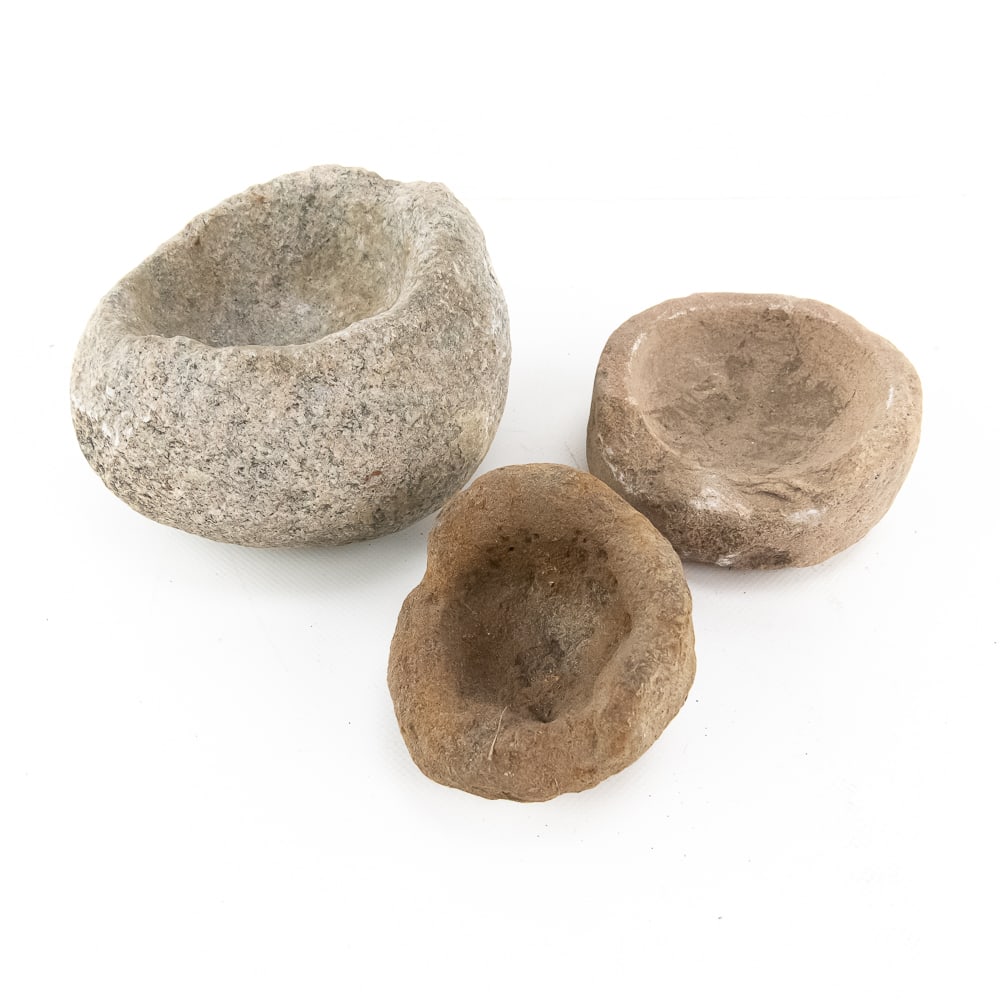 Trio of Primitive Stone Mortar Bowls (3): This fascinating trio of primitive stone mortars showcases the essential tools of early domestic life, likely used for grinding pigments, herbs, or medicinal preparations. Each piece is hand-hewn