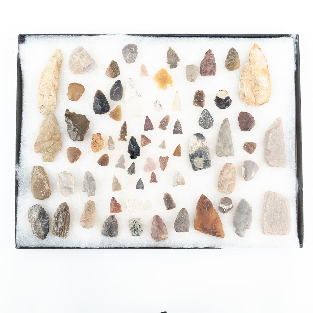 70pc Assorted Native American Lithics: This diverse collection of approximately 70 lithic artifacts showcases a wide range of prehistoric tool-making traditions, featuring various points, scrapers, and bifacial tools. The assembly includes