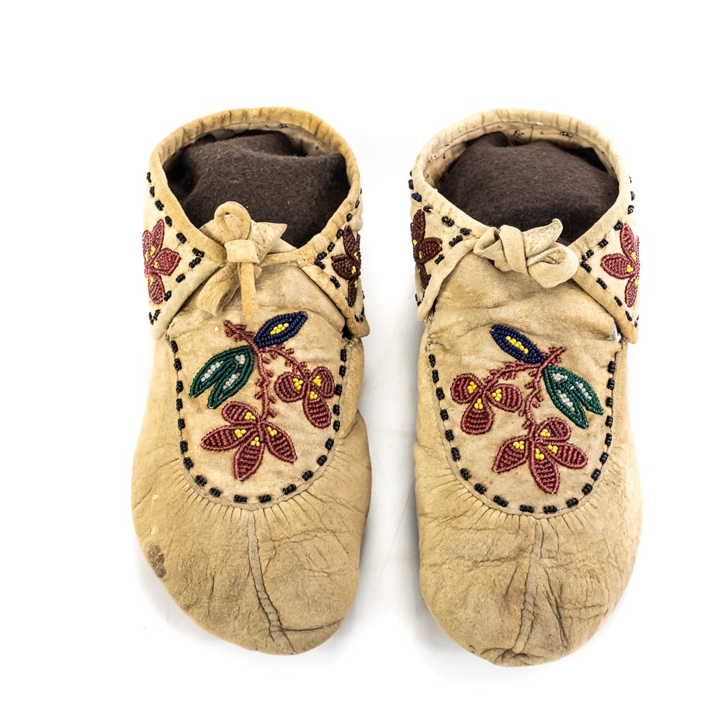 Pair of Beaded Moccasins-Floral: This exceptional pair of Native American soft-sole moccasins showcases classic Woodland or Great Lakes region styling, crafted in the mid-to-late 20th century. Made from supple, smoke-tanned