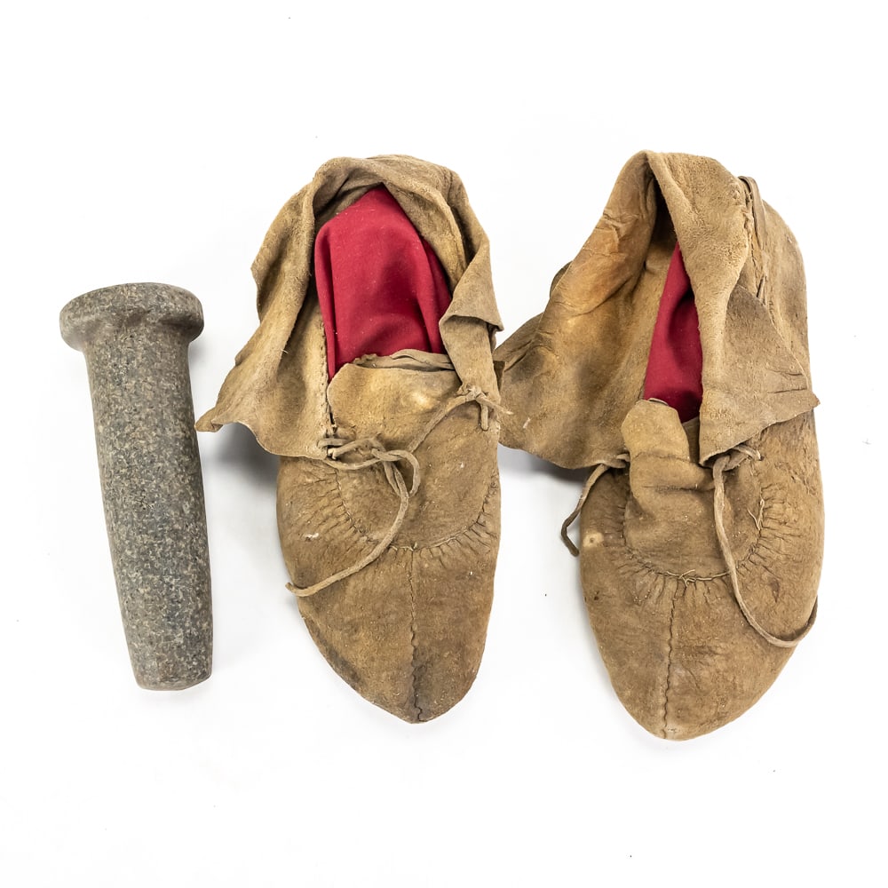 Antique Concave Stone Pestle & Leather Moccasins: This fascinating historical grouping includes a primitive stone pestle and a pair of hand-stitched leather moccasins. The pestle is expertly shaped from speckled granite with a unique concave