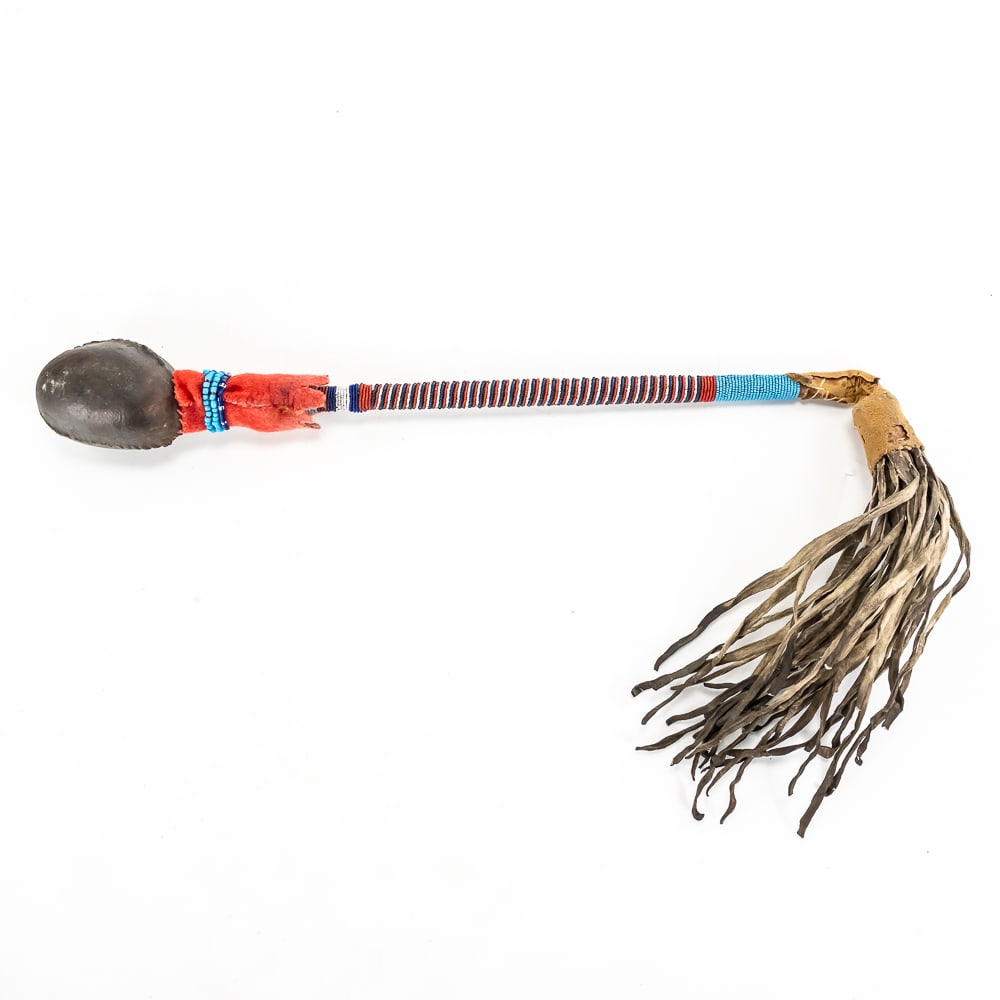 Beaded Native American Plains War Club: This striking Plains-style war club represents a fine example of traditional craftsmanship, featuring a stone head securely encased in stitched rawhide. The wooden shaft is meticulously adorned with