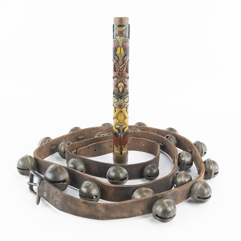 Primitive Folk Art & Sleigh Bell Lot: This distinctive primitive folk art pairing includes a full-length antique leather sleigh bell strap alongside a vibrant hand-carved wooden totem baton. The 87-inch body strap features twenty-four
