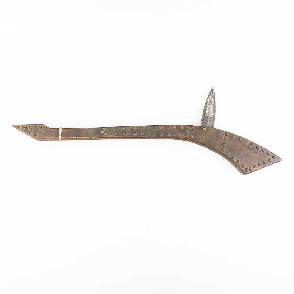 Gunstock Club w/Brass Tack Decor 1890s: This gunstock war club dates from the 1890s. Featuring a slender wooden handle that widens towards the head reminiscent of a gun stock. The base of the handle comes to an off-center point. The handle