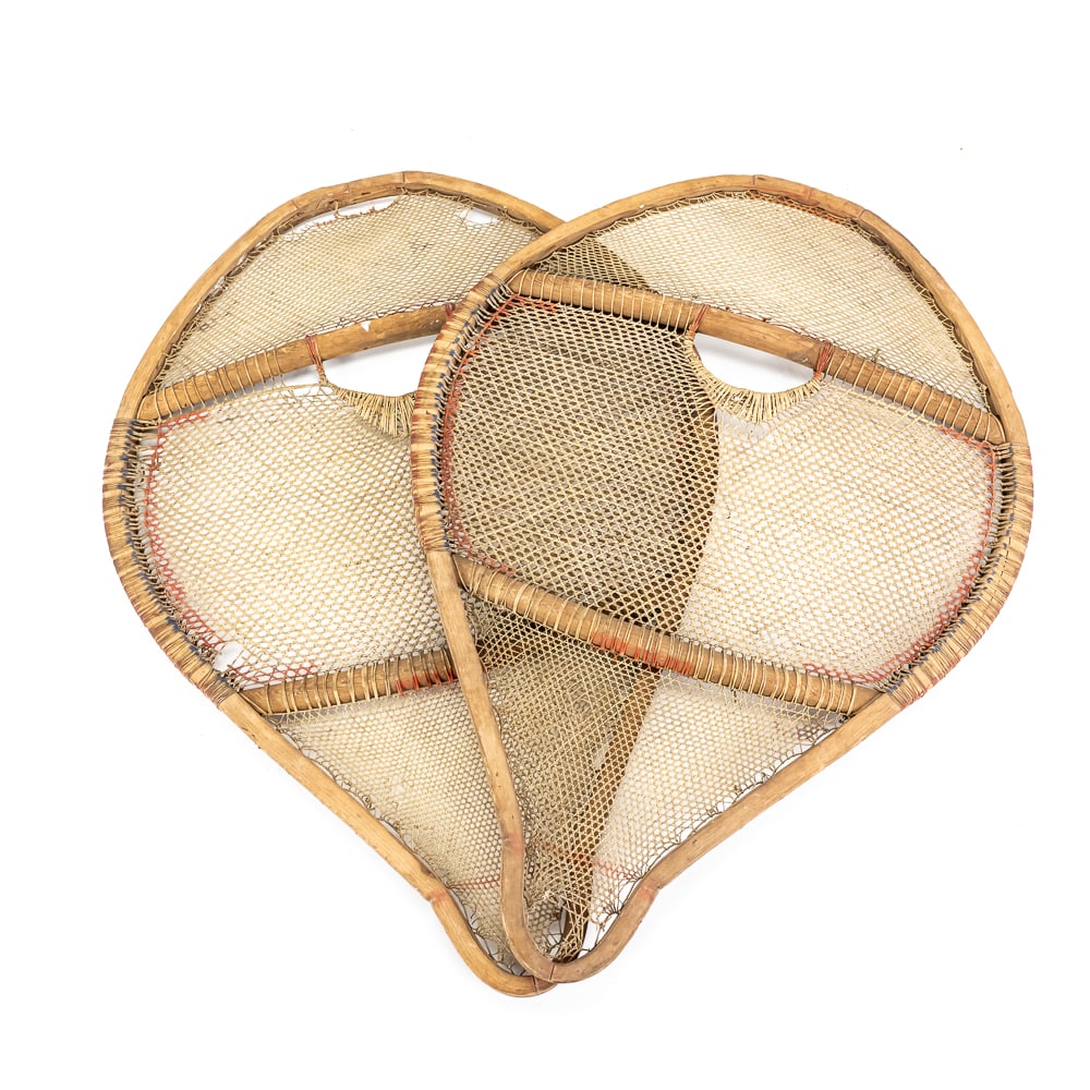 Vintage Bearpaw Style Wooden Snowshoes: These classic "Bearpaw" style snowshoes are a testament to traditional winter craftsmanship, likely dating from the mid-20th century. Constructed with sturdy steam-bent wood frames and intricate