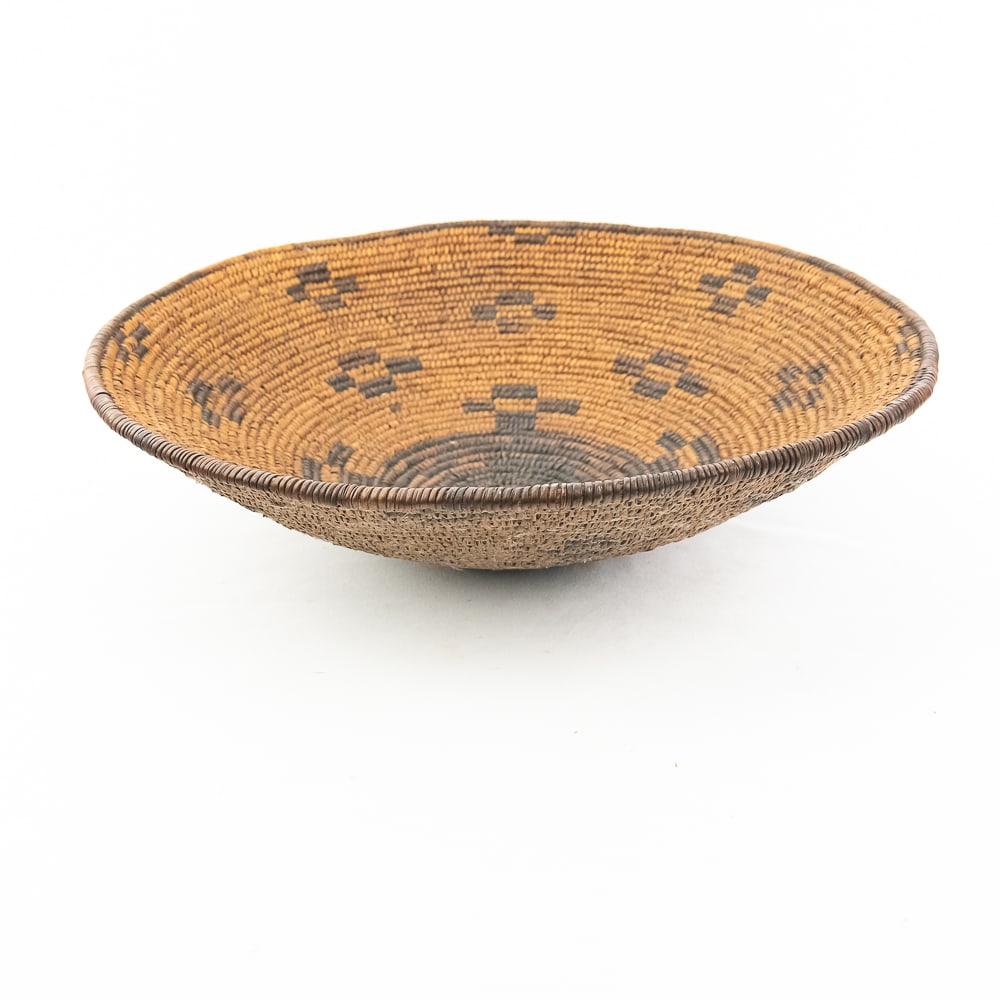 1920 Pima Basket: Pima basket circa 1920. Finally coiled shallow bowl showcases masterful artistry. Woven from natural plant fibers, likely willow or devil's claw, it has a warm brown hue with dark contrasting fibers f