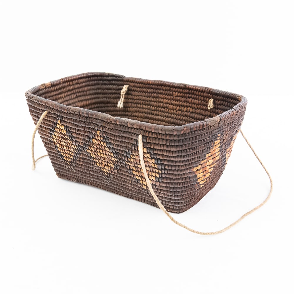 1930s Salish NW Coast Basket: Salish Northwest Coast rectangular basket circa 1930s. Made from woven cedar root or similar natural fibers, showcasing traditional craftsmanship. Features dark brown or reddish-brown base color,