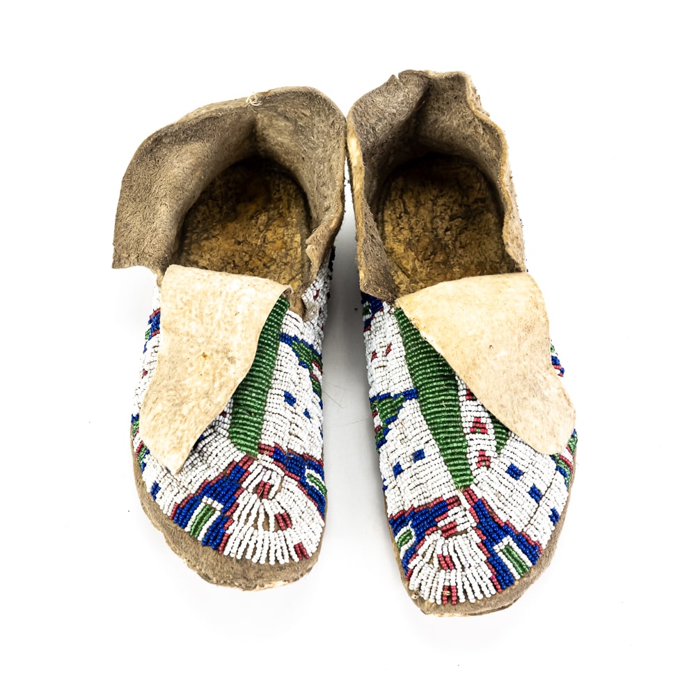 Sioux Beaded Hide Moccasins Pair: These late 19th to early 20th-century Lakota (Sioux) moccasins are a superb example of indigenous craftsmanship, characterized by their exceptional preservation. Hand-constructed from soft-tanned
