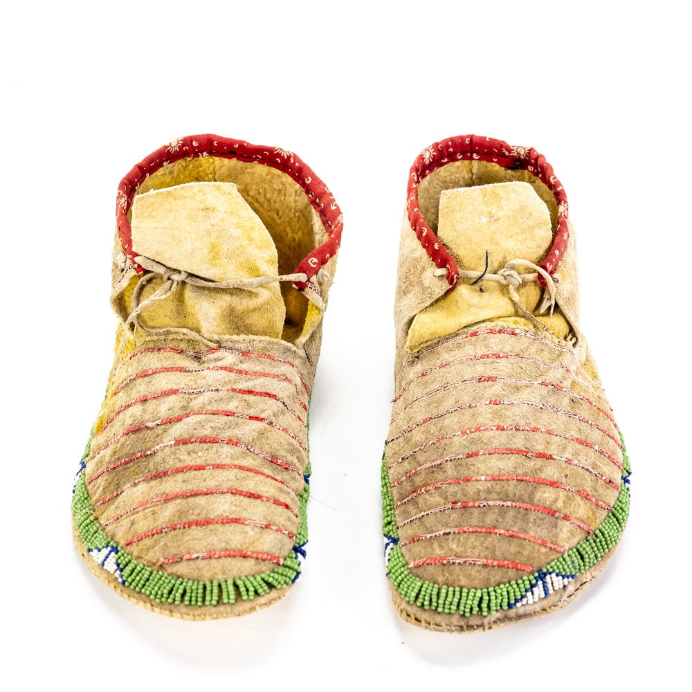 Native American Beaded & Quilled Moccasins Pair: This pair of hard-sole moccasins is a classic example of late 19th or early 20th-century Great Plains craftsmanship, likely of Sioux or Cheyenne origin. The construction utilizes authentic