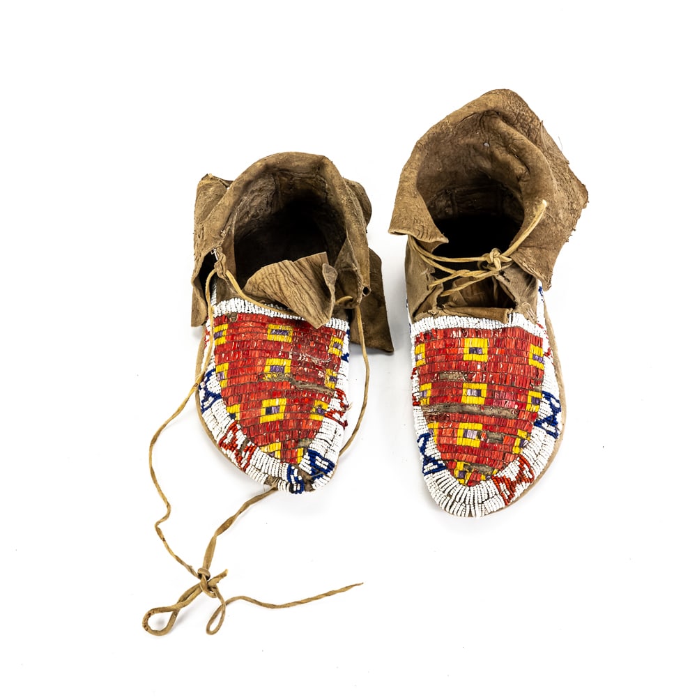 Plains Indian Beaded & Quilled Moccasins Pair: These late 19th to early 20th-century Native American moccasins, likely of Sioux (Lakota) or Cheyenne origin, represent a masterclass in Plains artistry. The design features traditional "lazy stitch"