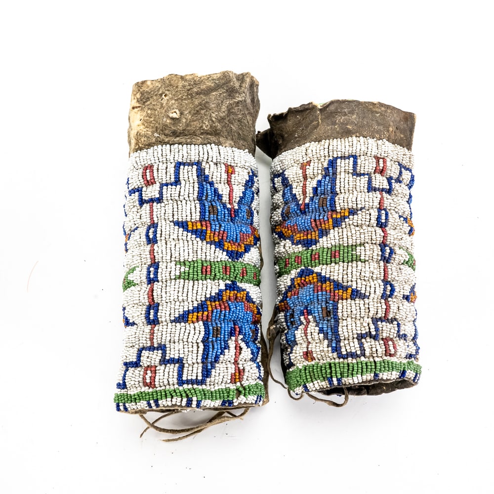 Antique Plateau Transmontane Beaded Hide Cuffs: This exceptional pair of late 19th-century Native American beaded cuffs represents a classic example of Transmontane (Plateau/Crow) geometric artistry. Hand-stitched onto brain-tanned hide, the