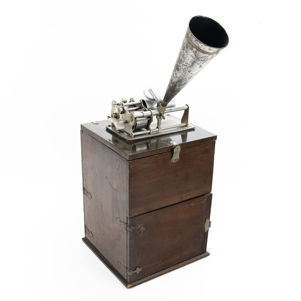 Columbia Eagle Cyl Phono In A French Travel Case: A nickel plated Columbia Eagle mounted on a tall flip top mahogany wood case with horn and record storage below. Phonograph has good plating and should clean up well. Winds and runs strong but needs a