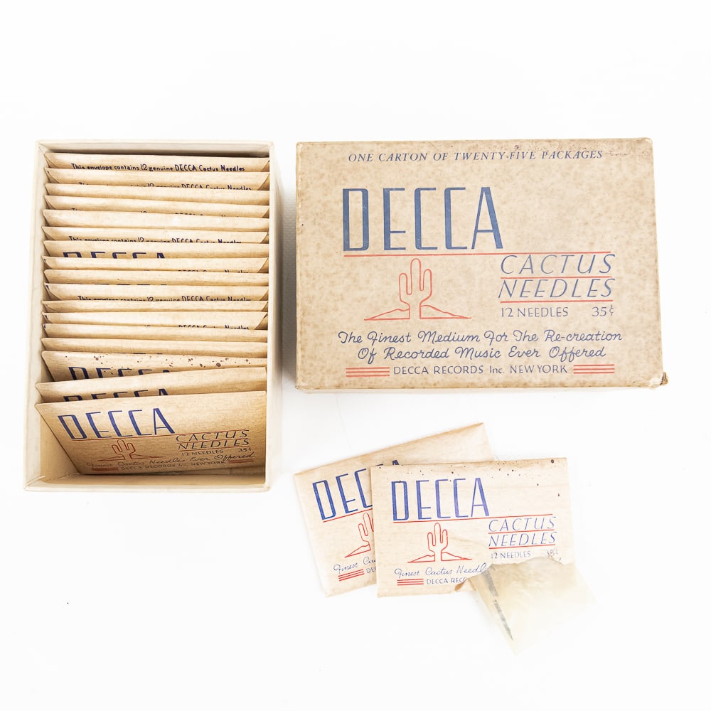Lot of 19 Decca Cacti Needle Packets: 19 unopened paper envelopes containing Decca cacti needles, all of which are contained in an original two-piece cardboard box featuring advertising on the top cover. In average condition with the