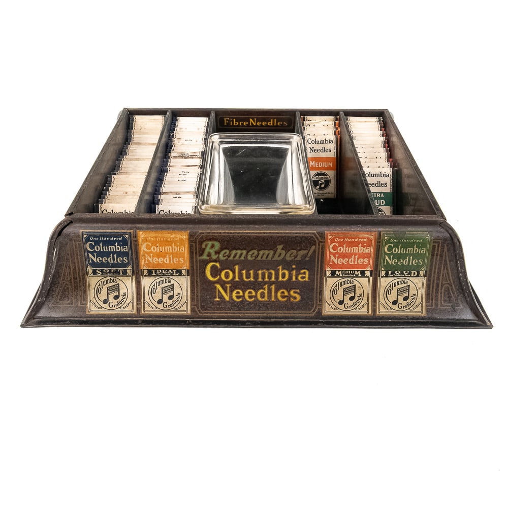 Countertop Columbia Phonograph Needle Display: Nice tin litho countertop needle merchandiser for Columbia phonograph needles. Comes with 80 packets of Columbia needles. Measures 15" wide, 12"deep, 3" tall. From the Allen Koenigsberg collection.