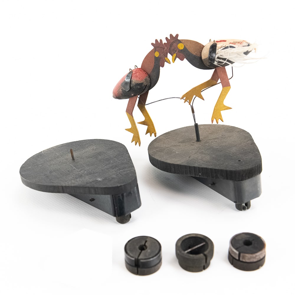 Parts Lot of Dancing Phonograph Toys: Useful lot featuring two original drive mechanisms, one original fighting cocks or roosters, and several extra wooden driving bushings. The fighting roosters are in fair condition with damage to the f