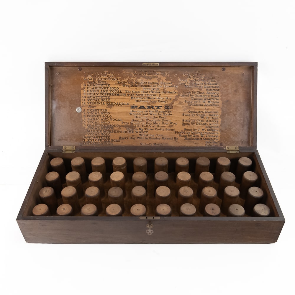 Wood Cylinder Phonograph Record Case: Solid wood case with locking hinged lid (key included) opens to reveal 40 wood pegs. Inside lid of case has a paper concert program of 24 selections in 2 parts so this must have been part of a