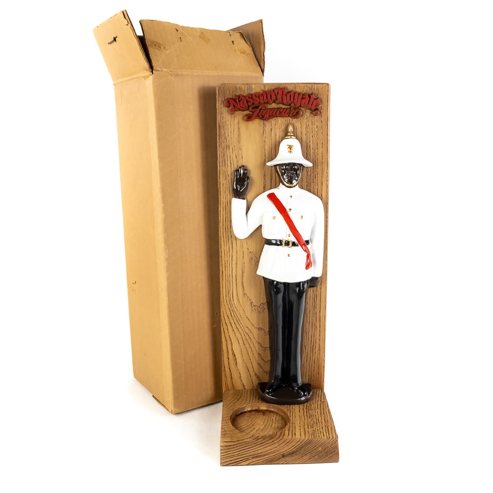 Vintage NOS Nassau Royale Liqueur Display Stand: Vintage NOS Nassau Royale Liqueur Display Stand, ceramic Bahamian Royal Police Force Officer figurine in his iconic white tunic, black trousers, red sash, and white pith helmet, wooden bar display use