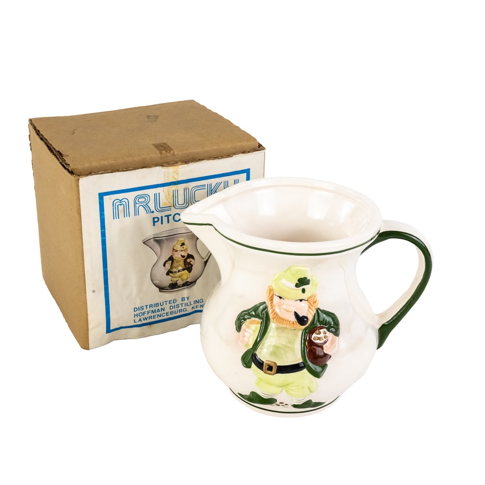 Vintage 1978 Hoffman "Mr. Lucky" Drink Pitcher: Vintage 1978 Hoffman "Mr. Lucky" Drink Pitcher, manufactured by Sun God, raised relief leprechaun smoking a pipe and holding a pot of gold, new in original box, see photos. 5 1/2" tall