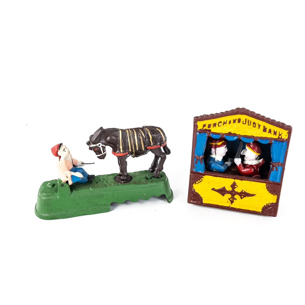 (2) Reproduction Mechanical Cast Iron Banks: (2) Reproduction Mechanical Cast Iron Banks includes a classic Punch and Judy bank, originally designed in 1884, to operate, pull lever on right side to cock the mechanism, place coin on Judy's frying