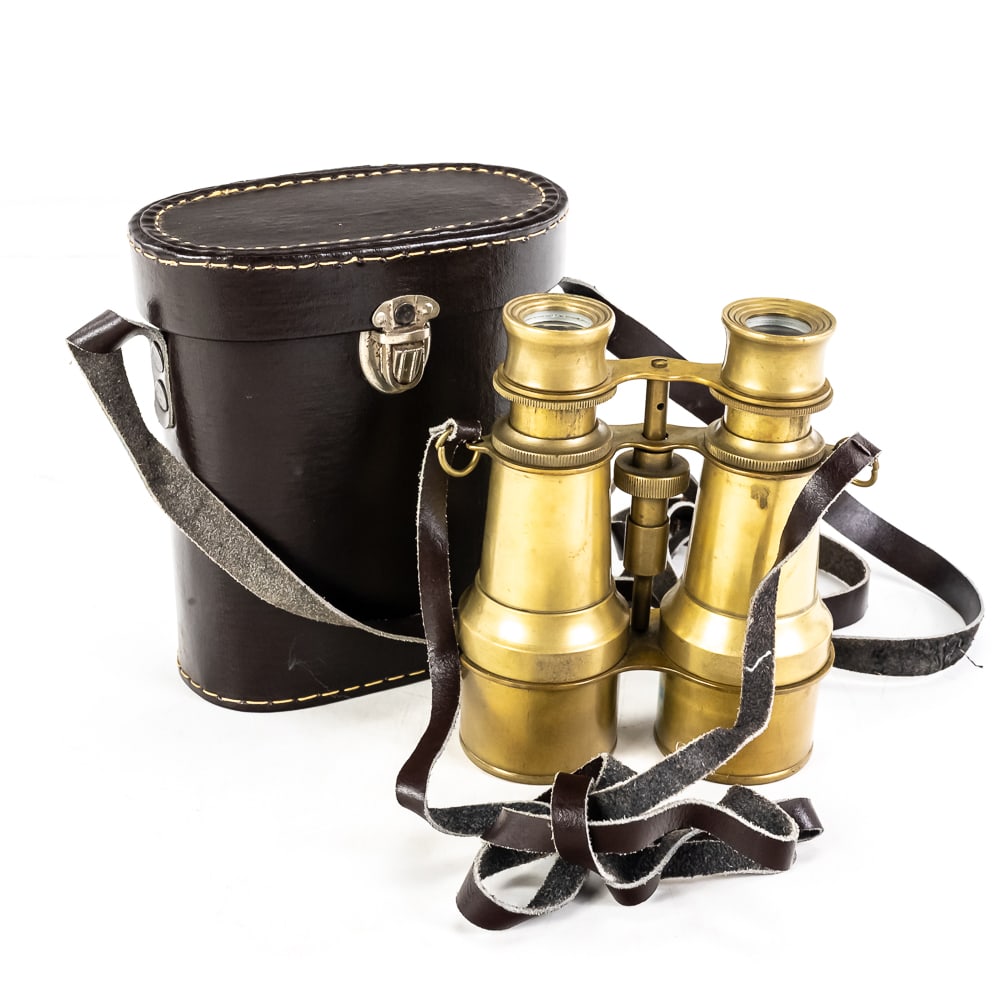 Antique-Style Solid Brass Field Binoculars: Antique-Style Solid Brass Field Binoculars, polished brass, central focus adjustment wheel, used for maritime navigation or military spotting, dark brown leather carrying case, lenses are clear, no