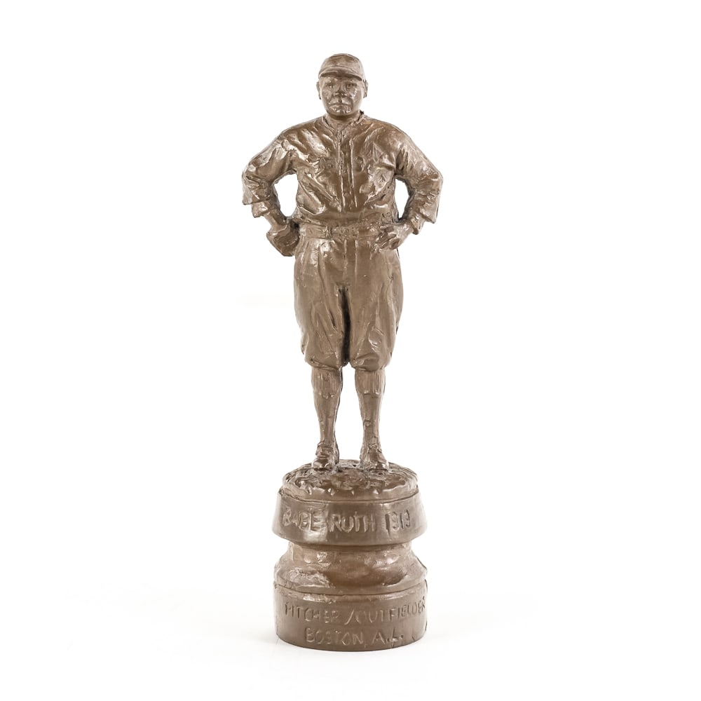 Babe Ruth Mini Sculpture – 1919: Title: Babe Ruth Mini Sculpture – 1919Sculpture Artist: Palmer MurphyDate of Sculpture by Murphy: 1997Inscriptions on Artwork: (front) PITCHER / OUTFIELD – BOSTON, A.L. (rear) 1997 –