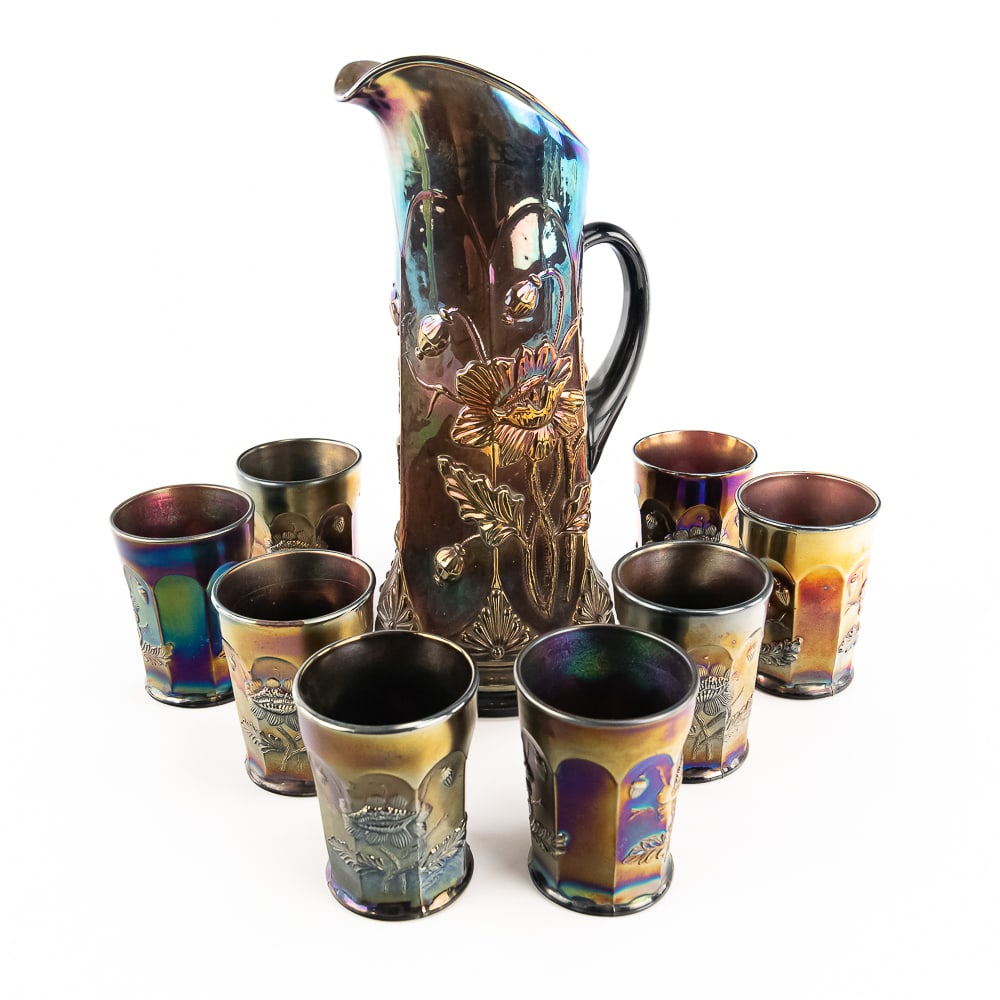 Carnival Glass N'wood Oriental Poppy 9pc Water Set: Pitcher and 8 matching tumblers in amethyst purple. Tumblers are in fine condition. The pitcher has an in-the-making wrinkle in the glass on the top rim, which causes no harm.See photos to judge condi