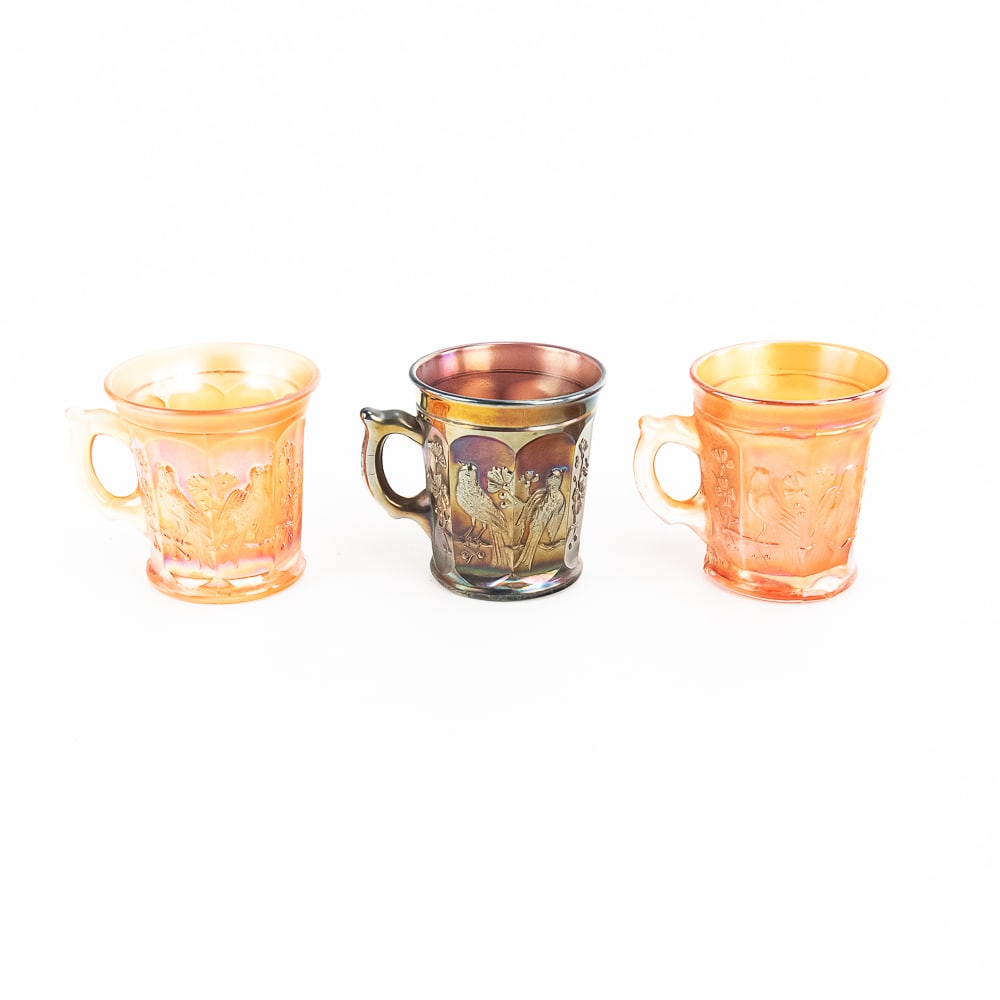 Carnival Glass: N'wood Bird Mugs 3-Pc: 3-piece lot of Northwood Singing Birds mugs. Two in marigold (very pretty iridescence) and one in amethyst (lighter color). All are in very good condition. See photos to judge condition and bid accord