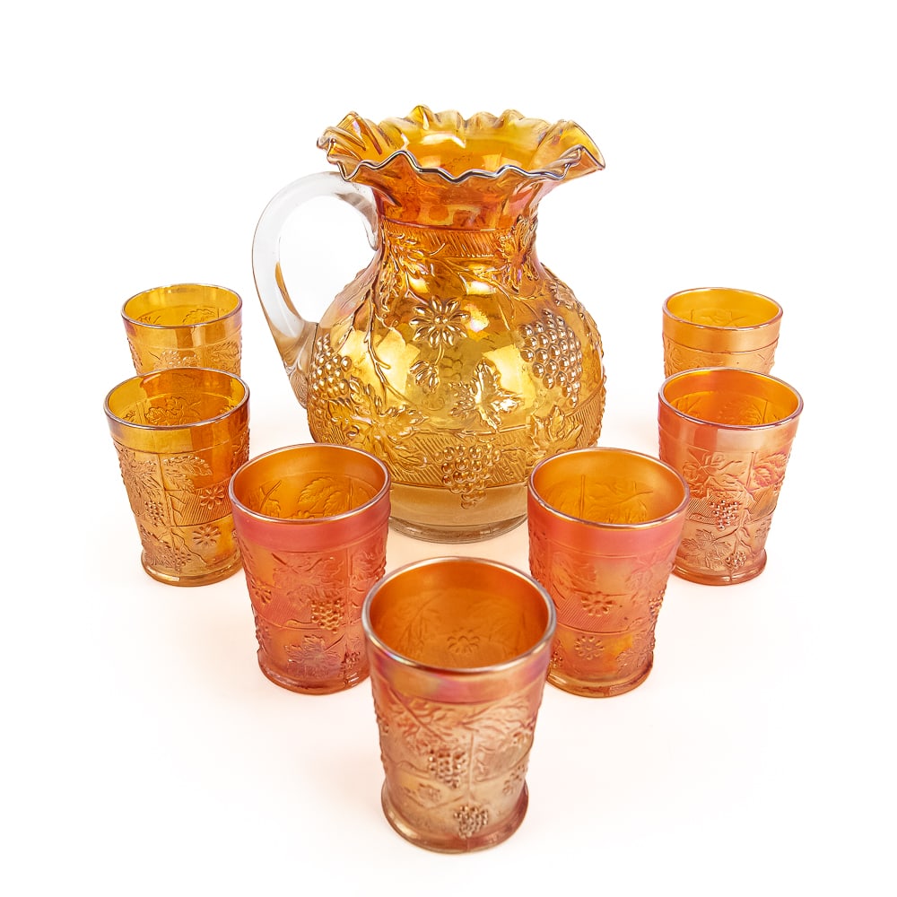 Carnival Glass Floral & Grape 8-Pc Water Set: This Dugan/Diamond set has a Pitcher with a crimped top in good condition with no issues. All tumblers have a bit of roughness on the bottom, and one has in-the-making roughness around the rim. See ph
