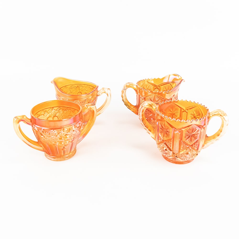 Carnival Glass: 4-Pc Lot: Includes a matching creamer and sugar in the Imperial Star Medallion pattern (pitcher has a base chip), and a creamer and sugar in the Northwood Gothic Arches pattern. Both sets are in marigold. Good 