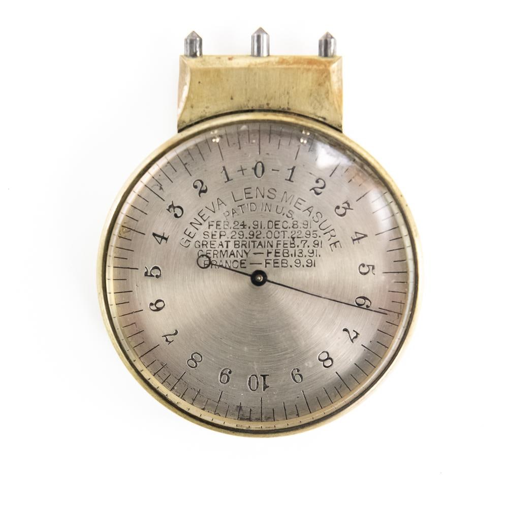 Geneva Lens Measure Optical Gauge: This late 19th-century scientific gauge is a classic Geneva Lens Measure (spherometer), designed to determine the dioptric curvature of optical lenses. Housed in a brass casing with a silvered dial
