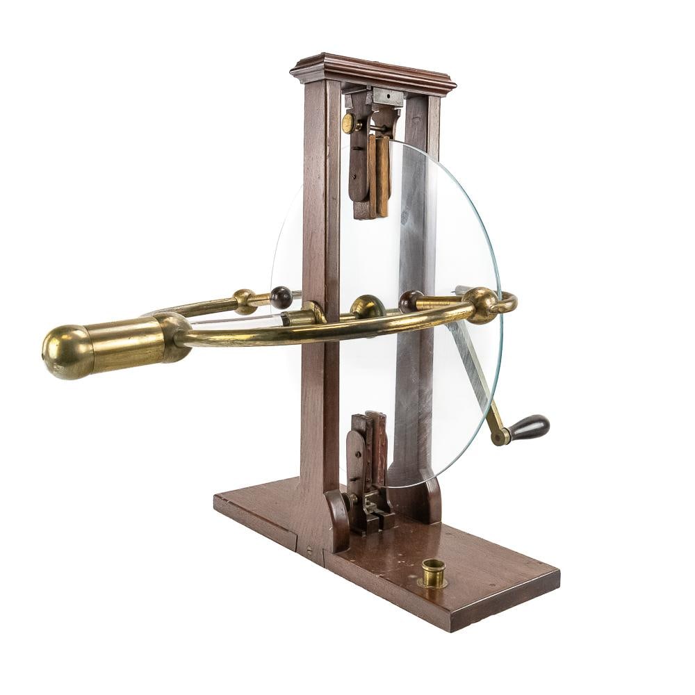 19th C. Ramsden Friction Electrostatic Generator: This exceptional 19th-century Ramsden-style friction electrostatic generator features a large, rotating glass disc supported by a handsome, solid mahogany double-pillar frame. A superb example of